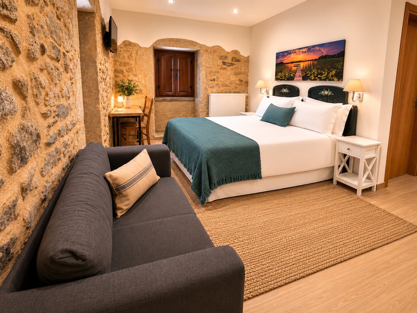 Habitación Camelia, la más amplia, con sofá, cama grande y muros de piedra