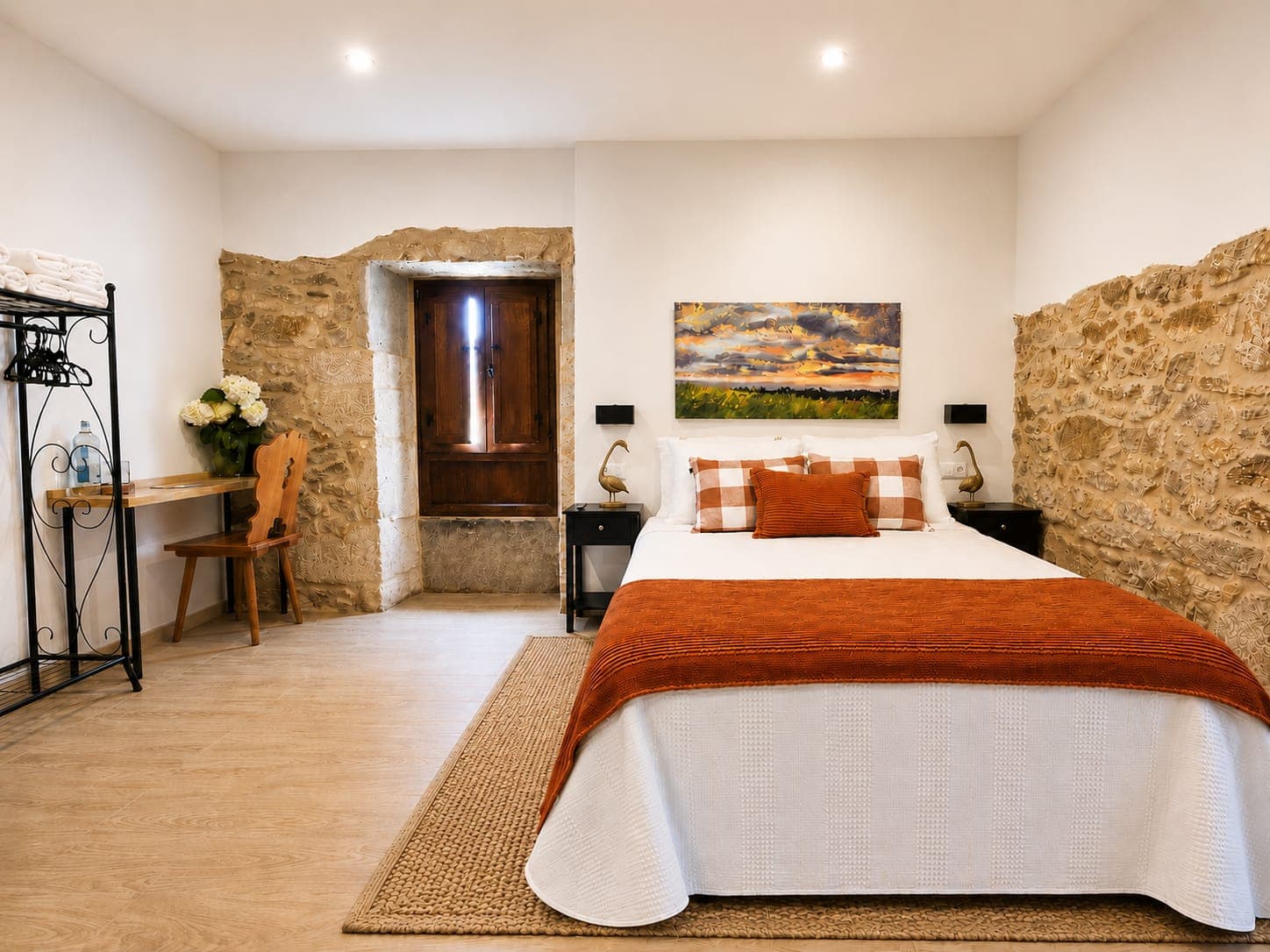 Habitación Magnolia luminosa con muros de piedra y detalles en tono terracota